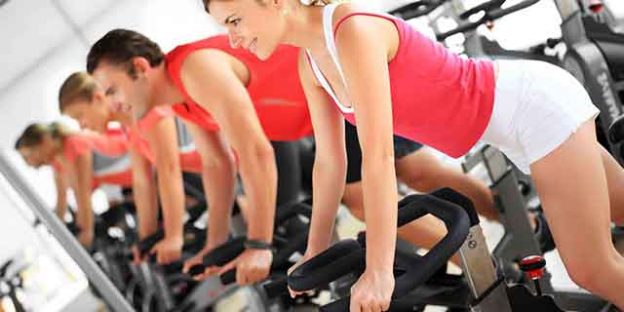 chicas y chicos en clase de spinning