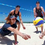 lanzados a rematar el balón en la playa